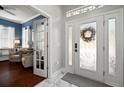 Bright foyer with a decorative front door, marble flooring, and view into the front office at 5715 Sea Trout Pl, Apollo Beach, FL 33572