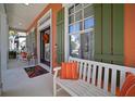 Inviting front porch features a white bench, colorful accents, and green shutters at 5715 Sea Trout Pl, Apollo Beach, FL 33572