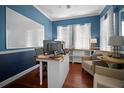 Home office with dark blue walls, a built-in bookshelf, and wood flooring at 5715 Sea Trout Pl, Apollo Beach, FL 33572
