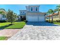 Beautiful home with a pristine lawn, mature palm trees, and an expansive driveway leading to a spacious three-car garage at 5822 Title Row Dr, Bradenton, FL 34210