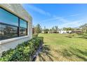 Expansive green backyard with manicured lawn and mature shrubbery offering a serene outdoor space at 622 Spring Lakes Blvd, Bradenton, FL 34210
