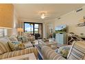 Inviting living room with sliding doors to the lanai, comfortable seating, and a ceiling fan at 6519 Grand Estuary Trl # 101, Bradenton, FL 34212