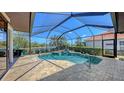A screened-in pool with brick patio overlooks the lake at 6621 The Masters Ave, Lakewood Ranch, FL 34202