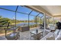 Inviting screened patio with comfortable seating and stunning views of the serene lake, perfect for outdoor relaxation at 6621 The Masters Ave, Lakewood Ranch, FL 34202