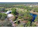 Aerial view of the home featuring a bridge to the pond and barn on a large lot at 7108 229Th E St, Bradenton, FL 34211