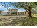 Charming two-story home with a metal roof, manicured landscaping, and a welcoming front porch at 7108 229Th E St, Bradenton, FL 34211