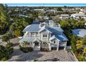 Aerial shot showcasing stunning home with balconies, pool, mature landscaping, and rooftop deck at 112 50Th St, Holmes Beach, FL 34217