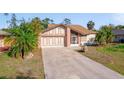 Charming single-story home with attached garage, landscaped yard, and long driveway at 1224 Inverness St, Port Charlotte, FL 33952