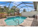 Relaxing screened-in pool with a soothing waterfall feature and a comfortable lounge chair for ultimate relaxation at 12245 Marsh Pointe Rd, Sarasota, FL 34238