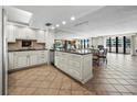 Open kitchen with island and modern appliances flows into the dining and living areas at 1485 Gulf Of Mexico Dr # 205, Longboat Key, FL 34228