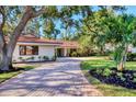 Well-maintained single-story home featuring mature landscaping and a winding brick driveway at 1610 S Lake Shore Dr, Sarasota, FL 34231