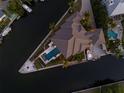 Expansive waterfront estate showcasing manicured landscaping, boat dock, pool, and ample parking at 242 Oak Ave, Anna Maria, FL 34216
