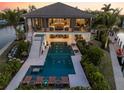 Enjoy a luxurious outdoor oasis with a sparkling pool, spa, and inviting lounge chairs for relaxation at 242 Oak Ave, Anna Maria, FL 34216