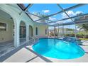 A stunning screened-in pool featuring a tranquil waterfall and inviting design at 2640 Geneva Rd, Venice, FL 34293