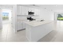Modern kitchen with white cabinetry, stainless steel appliances, and a spacious center island at 3707 Ambersweet Crossing, Parrish, FL 34219