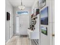 Bright entryway with tiled floor, decorative shelving, and a white front door leading to the home at 3826 Virga Blvd, Sarasota, FL 34233