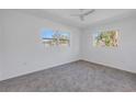 Bright bedroom with neutral carpet, ceiling fan, and two windows offering natural light at 4461 Maceachen Blvd, Sarasota, FL 34233