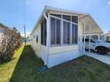 Exterior elevation showing a screened porch, covered parking and surrounding lawn area at 4923 5Th Street W Ct, Bradenton, FL 34207