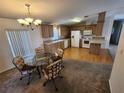 Open floor plan combining kitchen with wood floors and dining area with glass table at 4923 5Th Street W Ct, Bradenton, FL 34207