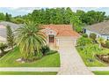 Charming home featuring a tile roof and a brick paved driveway, enhanced by lush landscaping and mature palm trees at 5308 88Th E St, Bradenton, FL 34211