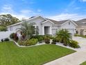 Well-manicured front yard with vibrant green grass and tropical landscaping at 559 Spotted Slipper Pl, Ruskin, FL 33570