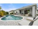 Inviting backyard features a sparkling pool and a comfortable patio area for relaxation at 559 Spotted Slipper Pl, Ruskin, FL 33570