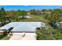 View of the home's roof and the adjacent golf course with mature trees and a water feature at 5621 Palm Aire Dr, Sarasota, FL 34243