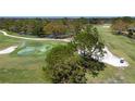 Aerial view of the beautiful lush green golf course featuring mature trees and a water feature at 5621 Palm Aire Dr, Sarasota, FL 34243