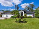 Beautiful one-story home featuring an arched entryway, lush front lawn, and a two car garage at 5646 Country Lakes Dr, Sarasota, FL 34243