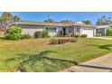 Landscaped front yard with healthy green grass, attractive flower bed, and a charming single-story home at 6732 Keystone Dr, Sarasota, FL 34231