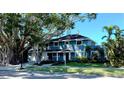 Charming two-story home featuring a well-manicured lawn, beautiful landscaping, and mature trees at 7735 Westmoreland Dr, Sarasota, FL 34243