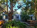 Home exterior showcasing a wooden deck area, outdoor dining set, hot tub, and lush greenery at 775 36Th S Ave, St Petersburg, FL 33705