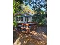 Cozy home exterior featuring a wooden deck area with rustic picnic table and benches, nestled among trees at 775 36Th S Ave, St Petersburg, FL 33705