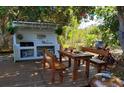 Outdoor kitchen and dining space, complete with lighting and lush backyard plants at 775 36Th S Ave, St Petersburg, FL 33705