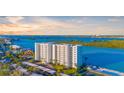 Waterfront condo building featuring private balconies overlooking a bay and lush landscape at 9393 Midnight Pass Rd # 506, Sarasota, FL 34242