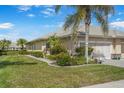 Charming home showcasing well-manicured landscaping, including lush green lawn and vibrant flower beds at 9847 Hawk Nest Ln, North Port, FL 34287