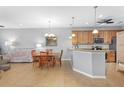 Open-concept kitchen and dining area with tile floors, pendant lighting, and modern appliances at 9847 Hawk Nest Ln, North Port, FL 34287