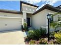 Home's entryway features attractive landscaping and a covered porch area at 10179 Milky Way Cir, Sarasota, FL 34241