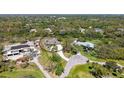 Expansive aerial view showcasing the home nestled within a lush, green landscape with surrounding trees and circular driveway at 1030 Bahia Vista Ct, Sarasota, FL 34232