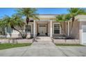 Welcoming home entrance with double doors, decorative pillars, and tropical landscaping for curb appeal at 1030 Bahia Vista Ct, Sarasota, FL 34232