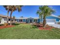 Charming curb appeal with vibrant blue exterior, mature palms, and well-manicured lawn at 108 Peckham Sw St, Port Charlotte, FL 33952