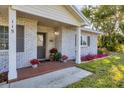 Charming front porch featuring brick accents, potted plants, and a welcoming entrance at 115 65Th Street Nw Ct, Bradenton, FL 34209