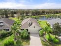 Aerial view of the property showcasing a well-maintained lawn, pond view, and beautiful landscaping at 11742 Forest Park Cir, Bradenton, FL 34211