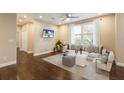Bright living room with hardwood floors, a ceiling fan, and a large window providing ample natural light at 11936 82Nd E St, Parrish, FL 34219