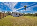 Expansive backyard with well-maintained lawn, bordered by a new wooden fence and mature trees at 221 Laurel E Rd, Nokomis, FL 34275