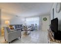 Inviting living room featuring tile floors, neutral paint, a comfortable sofa, and ample natural light at 2412 Grove St, Sarasota, FL 34239