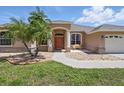 Charming single-story home featuring a manicured lawn, stone accents, covered entry, and bench at 3218 45Th E Way, Bradenton, FL 34203