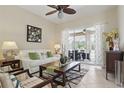 Bright living room with tiled floors, ceiling fan, and sliding glass doors leading to the outdoor patio at 3218 45Th E Way, Bradenton, FL 34203