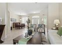 Open-concept living room with tiled floors, dining area, and large windows that bring in natural light at 3218 45Th E Way, Bradenton, FL 34203