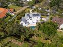 Aerial view featuring a home with a backyard pool, deck, lush greenery, and solar panels at 3648 Beneva Oaks Blvd, Sarasota, FL 34238
